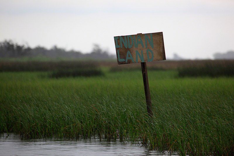 Louisiana wetlands with sign reading Indian Land. Photo by Erika Blumenfeld.